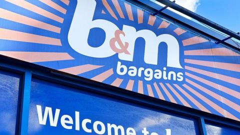 The top of a B&M shop with showing a shop logo the white writing has a dark blue and orange background.