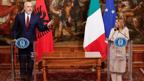 Albania's Edi Rama and Italy's Giorgia Meloni standing in front of two lecterns, as well as the Italian and Albanian flags, at the press conference in Rome