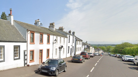 A google image of Polnoon Street in Eaglesham, with a number of cars parked in the road outside whitewashed houses