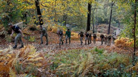 Members of the military take part in the tri-service Gurkha Doko race, carrying a Doko, a traditional Nepalese bamboo basket, at the Army Training Centre in Pirbright, Surrey. 