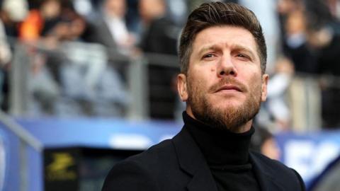 Head and shoulders view of a bearded Sebastien Pocognoli in black rollneck jumper and dark smart jacket