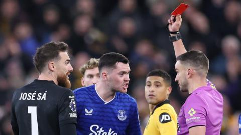 Michael Keane is shown a red card against Wolves