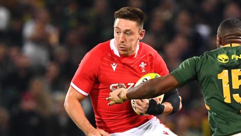 Josh Adams runs with the ball under his left arm for Wales in South Africa