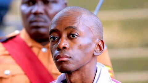 Christopher Okello Onyum stares into the distance, his face is expressionless.