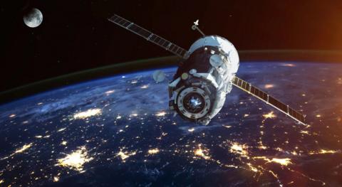 A satellite up in space. The earth can be seen in the image, as can the moon.