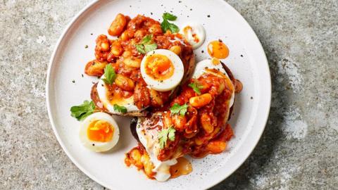 A plate of masala beans with jammy eggs and mango chutney yoghurt.
