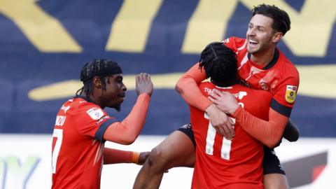 Luton celebrate taking the lead at Wigan