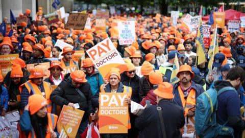 Consultants and Junior Doctors carry placards in a strike rally in Manchester on 3 October