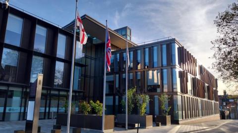 West Northamptonshire Council building. The union jack and St George flag are outside
