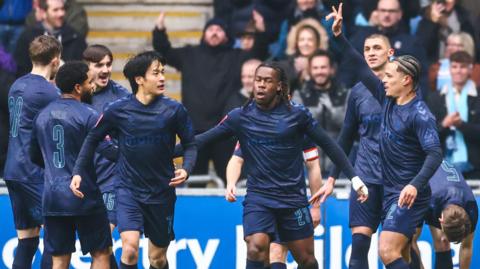 Coventry's players, in their navy blue strip to support the Zoe's Place charity, celebrate their only goal through Joel Latabeaudiere