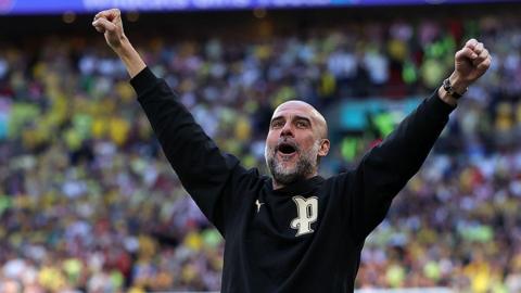 Manchester City boss Pep Guardiola celebrates with arms aloft on the touchline