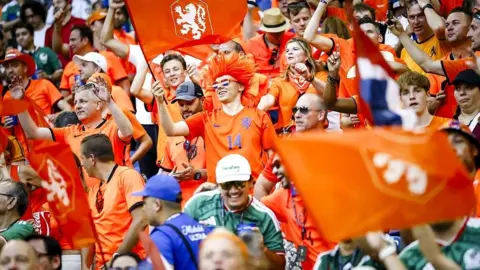 Dutch fans wearing orange and waving flags