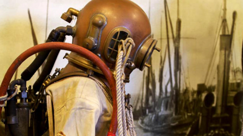 Early diving helmet in bronze on a statue in a museum