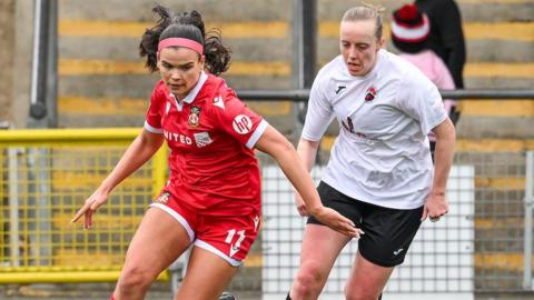 Amber Lightfoot (left) runs with the ball for Wrexham