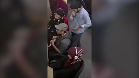 A high shot of four people sitting at computers at a call centre in Lahore