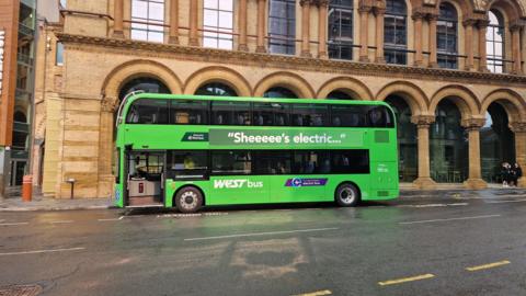 A green bus parked on a street.