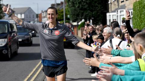 School children cheer on Jill Scott on the road during day five of the Coming Home Challenge in aid of Sport Relief