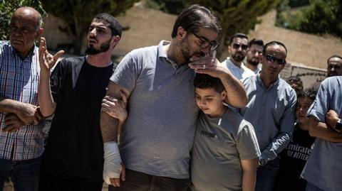 Fahd Abou Haikal, a Palestinian man comforts his elder son Kinan Abou Haikal after burying his seven-month-old baby Sam Fahd Abou Haikal, in Hebron, in the occupied West Bank 
