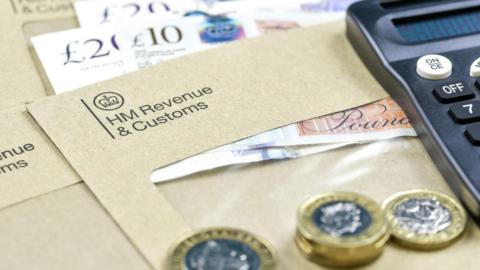 The logo of Her Majesty Revenue and Customs on envelope, with money or check included inside.