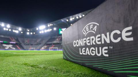 Uefa Conference League sign on a football pitch