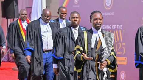 The Uganda Law Society (ULS) members wearing court ropes and walking away from an event