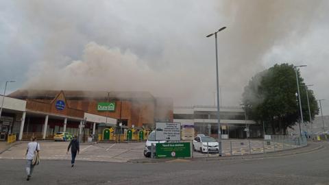 The outside of the Dunelm store in Yeovil. Grey smoke can be seen coming from the roof.