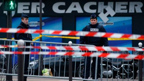 French police officers standing guard in front of a kosher grocery store in Porte de Vincennes, eastern Paris, on 10 January 2015, a day after four people were killed at the Jewish supermarket by jihadist gunman Amedy Coulibaly