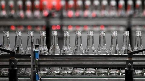 Glass bottles on a conveyor belt.