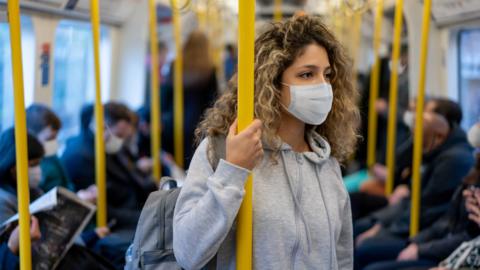 Woman on a train in a mask