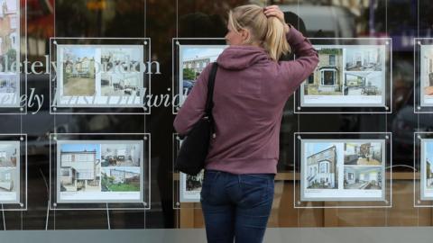 woman looking in estate agent