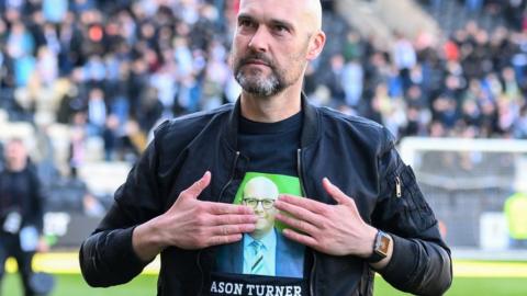 Notts County boss Luke Williams touches his shirt, which was in tribute of the club's late CEO Jason Turner