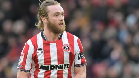 Tom Davies in action for Sheffield United in the club's red and white striped home jersey