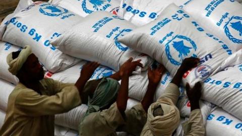 Sudanese workers offload US aid destined for South Sudan from the World Food Programme (WFP) at Port Sudan on March 19, 2017