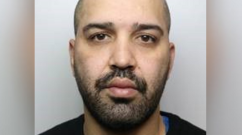 A mugshot of Mofrad on a grey background.