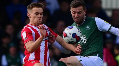 Matt Butcher and Archie Collins challenge for the ball