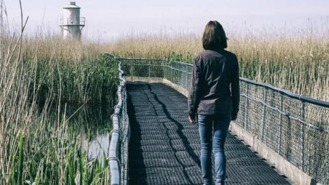 A woman walking towards West Usk Lighthouse on the Gwent Levels