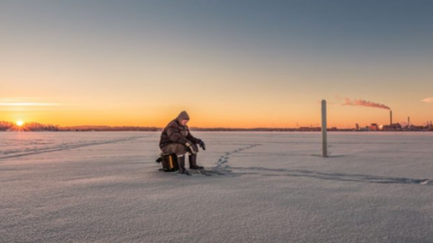 Angler on frozen lake, Estonia