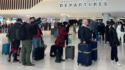 Passengers queue for security screening in the departures area of Terminal 2 at Manchester Airport in Manchester