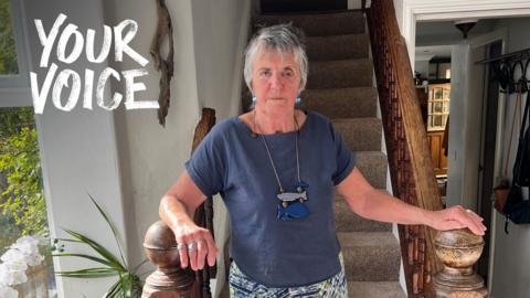 Sally stood at the bottom of her stairs