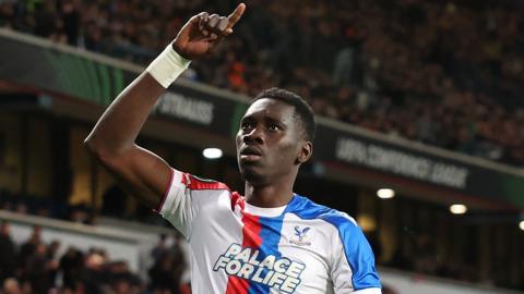 Ismaila Sarr raises his right arm and points to the sky with his index finger as he celebrates a goal for Crystal Palace