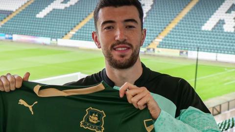 Finn Azaz poses with a Plymouth Argyle shirt