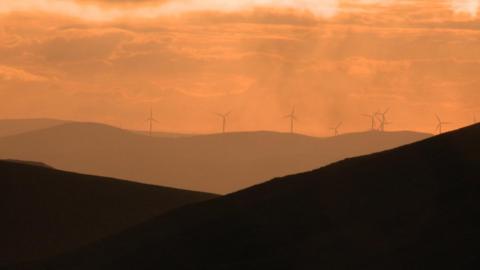 Wind turbines at the summit of Clyde Law, from where water trickles to