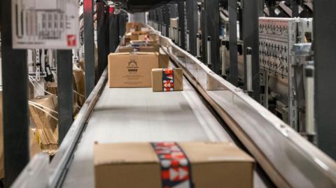 Parcels moving on a conveyor belt in a factory.