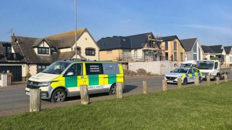 Ambulance and police car parked on a road