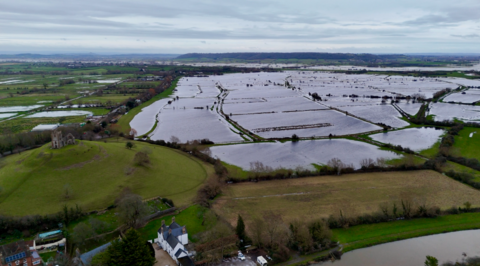 A drone shot showing flooded fields on the Somerset lewvels with a small village in the foreground