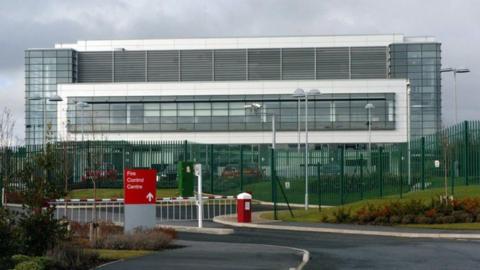 The former Wakefield Regional Fire Control Centre, a large glass building on a metal frame, with barriers across the entrance.