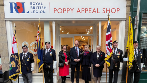 Lt Gov, Vice Admiral Jerry Kid, Dr Karen Kyd, RBL Jersey President, Tracey
Williams (right) and Poppy Appeal Organiser, Alison Opfermann (left) outside this year’s Poppy Shop in Jersey, flanked by standard bearers for the Royal British Legion
