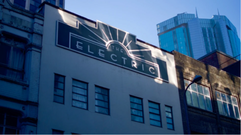 A close up of the Electric cinema. It is a white building with a black and white sign that says "The Electric" in thin font.