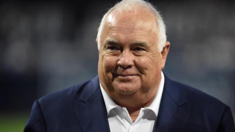 Ron Fowler pictured at a baseball game in white open-necked shirt and dark jacket while working as executive chairman of San Diego Padres