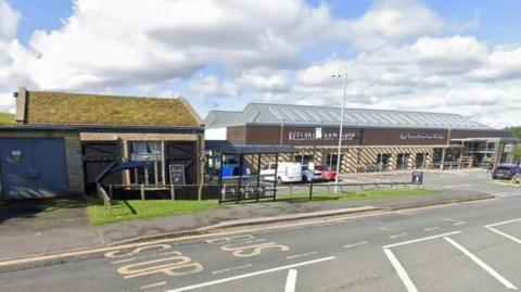 The outside of the Keelham Farm Shop building, with a car park and bus shelter next to it